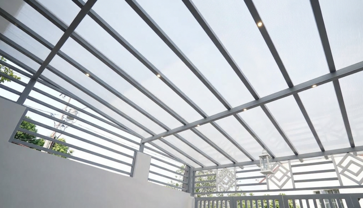 Twinwall polycarbonate carport roof installation with aluminum framing and diffused natural light.