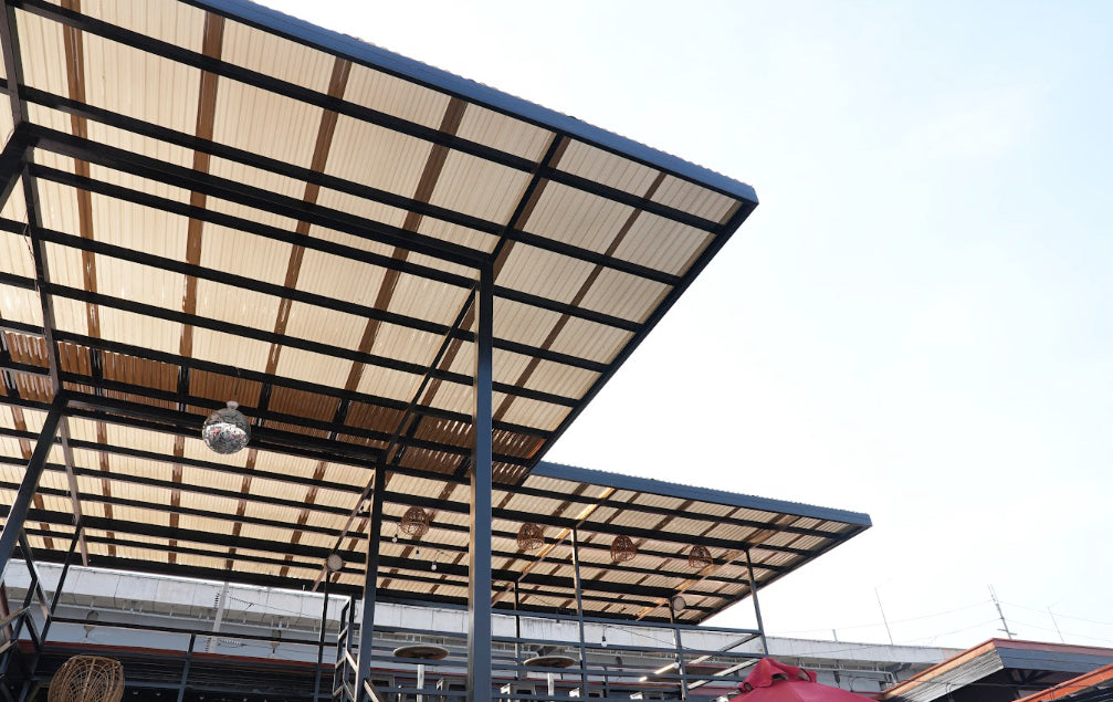 Modern outdoor patio featuring a durable rib type polycarbonate sheet roof with a black steel frame.